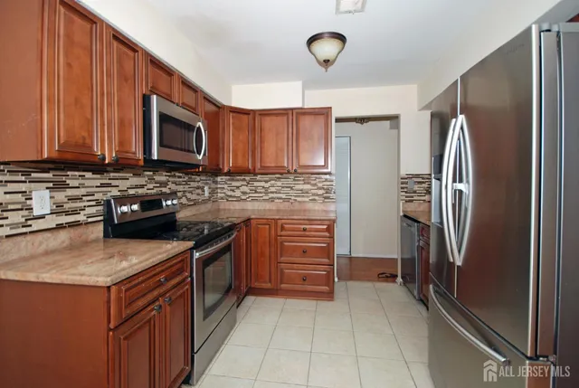 a kitchen with stainless steel appliances granite countertop a refrigerator stove and sink