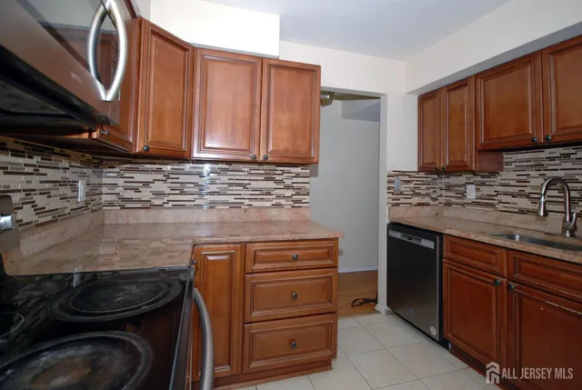a kitchen with granite countertop wooden cabinets and a stove top oven