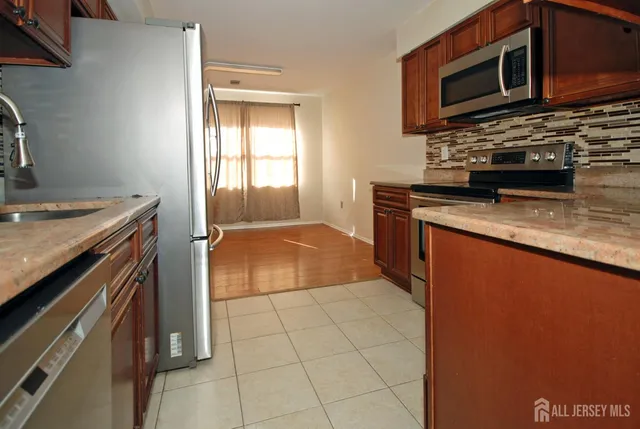 a kitchen with stainless steel appliances granite countertop a stove a microwave and a sink