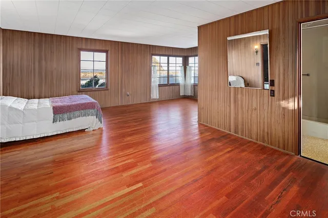 an empty room with windows cabinet and a bed