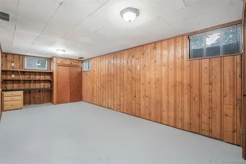 a view of an empty room with bookshelf and entryway