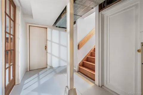a view of staircase with wooden floor and white walls