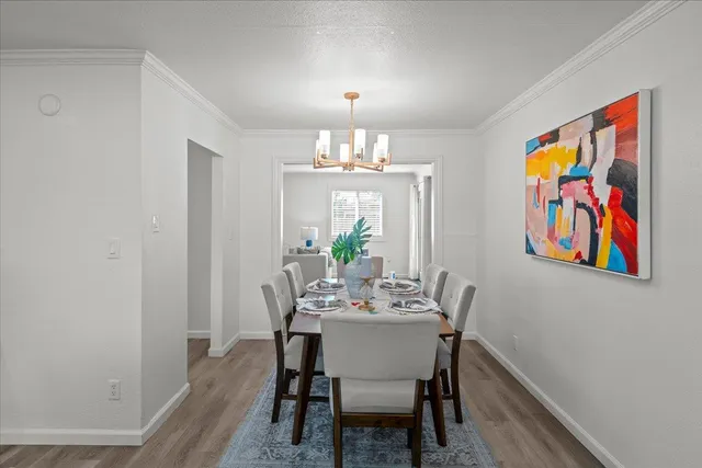 a view of a dining room with furniture wooden floor and a chandelier