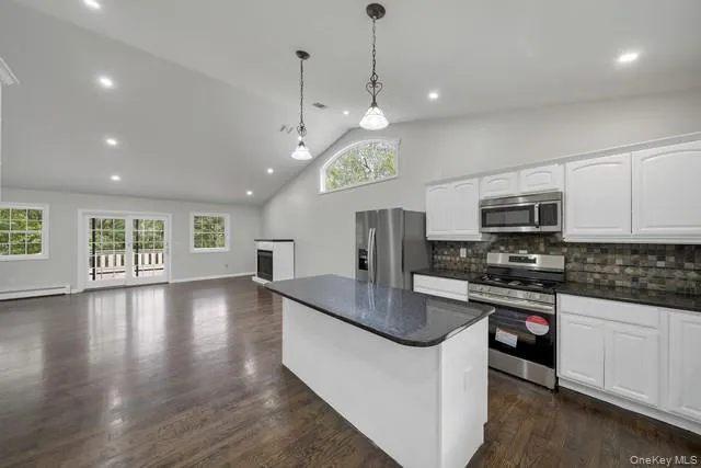 a kitchen with stainless steel appliances granite countertop a sink a stove and a wooden floors