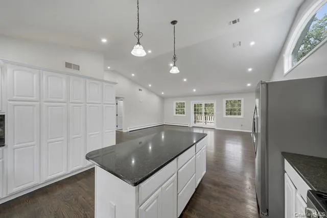 a kitchen with kitchen island a sink stainless steel appliances and cabinets