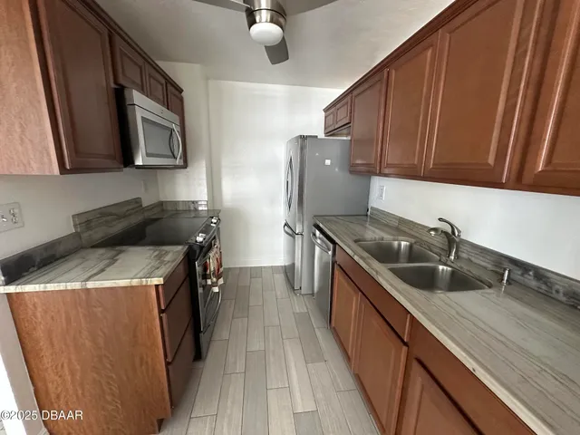 a kitchen with stainless steel appliances granite countertop a refrigerator sink and cabinets