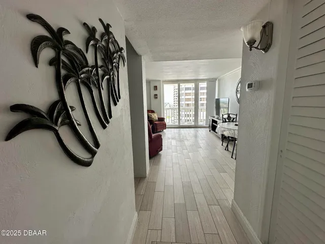 a view of an empty room with a window and wooden floor