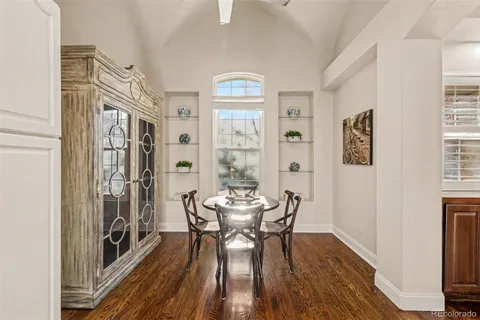 a kitchen with granite countertop stainless steel appliances a dining table and chairs