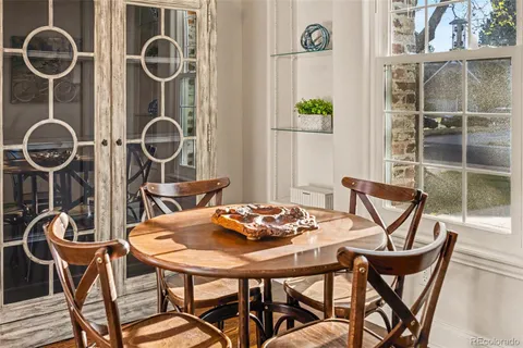 a kitchen with granite countertop a refrigerator a stove a dining table and chairs