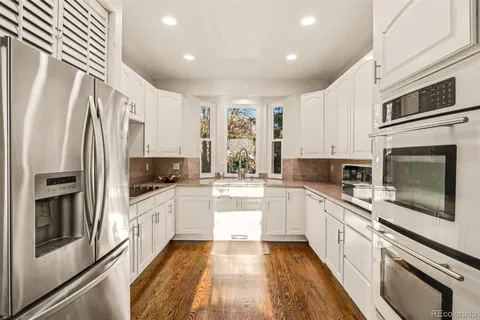 a kitchen with granite countertop white cabinets and white appliances