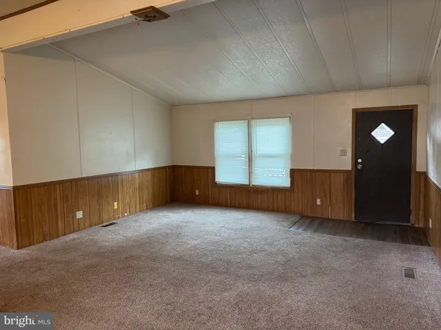 an empty room with closet and windows