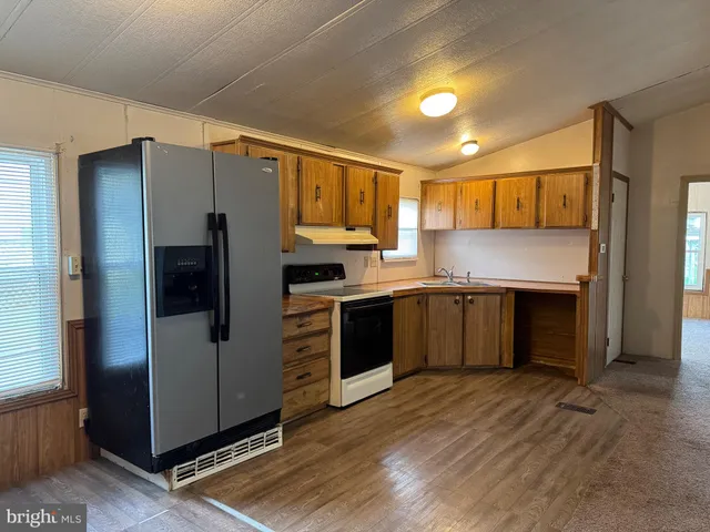 a kitchen with stainless steel appliances a refrigerator and a stove top oven