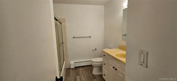 a bathroom with a granite countertop toilet and a sink