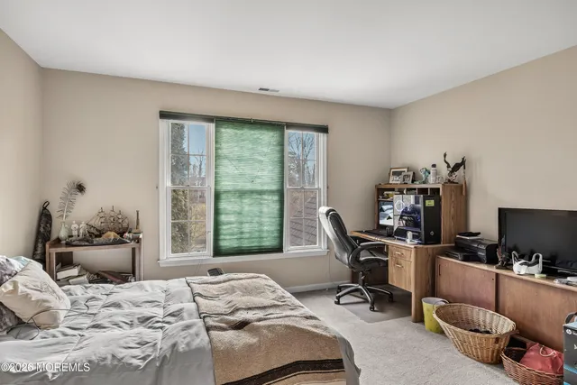 a bedroom with a bed next to a large window