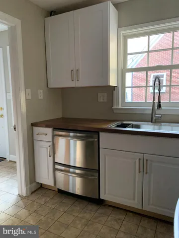 a kitchen with granite countertop white cabinets and white appliances