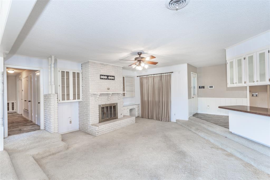 417 Willow Way Gainesville, TX 76240 - Photo 21 of 40 a view of a kitchen with a sink dishwasher and a fireplace