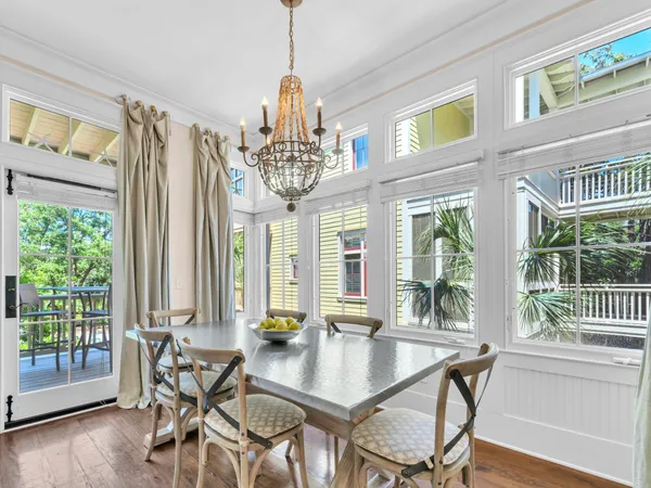 a view of a dining room with furniture large windows and wooden floor