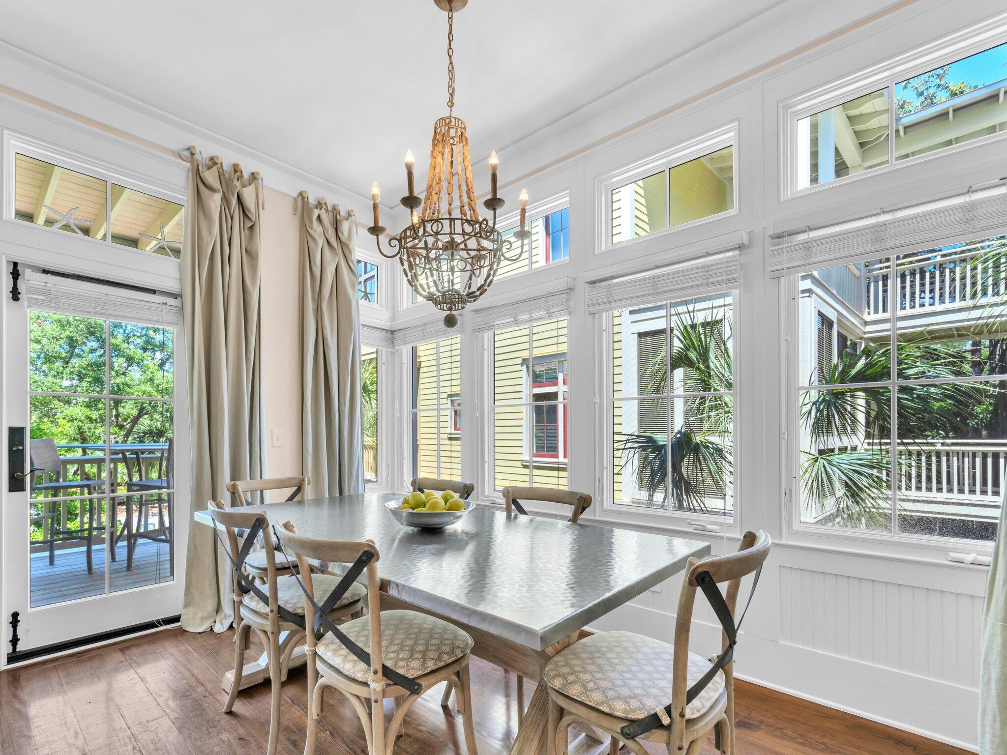 1660 East County Highway 30A, Unit 102 Santa Rosa Beach, FL 32459 - Photo 20 of 48 a view of a dining room with furniture large windows and wooden floor