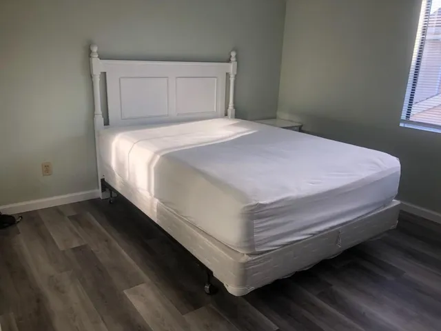 a bed sitting in a bedroom next to a window