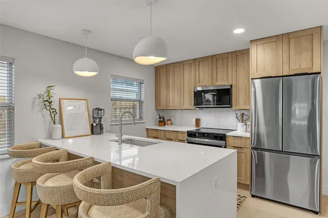 a kitchen with stainless steel appliances granite countertop a refrigerator stove and sink