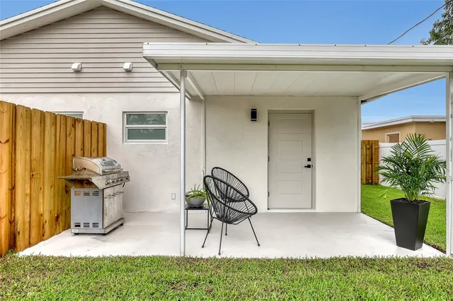a view of a backyard with table and chairs and wooden fence