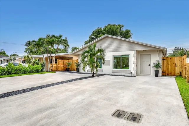 a view of a house with a yard and potted plants