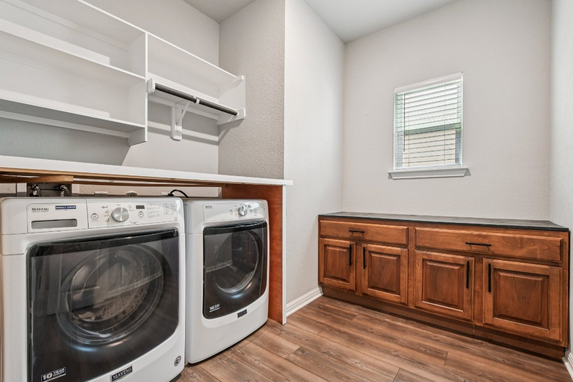 1007 Guadalupe Bass Road Hutto, TX 78634 - Photo 12 of 39 Washroom with dark wood-style floors and independent washer and dryer