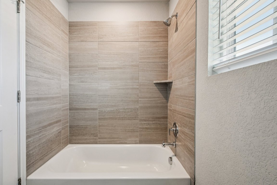 1007 Guadalupe Bass Road Hutto, TX 78634 - Photo 27 of 39 Full bath featuring shower / tub combination and a textured wall