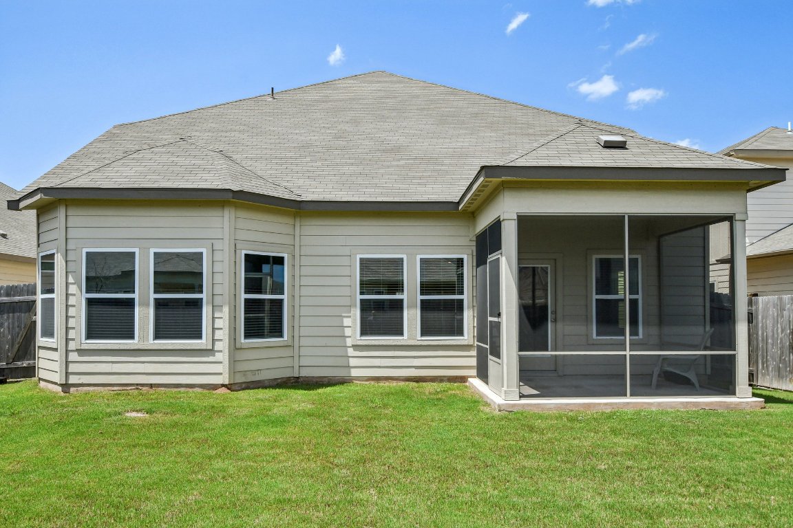 1007 Guadalupe Bass Road Hutto, TX 78634 - Photo 34 of 39 Back of house featuring a shingled roof and a sunroom