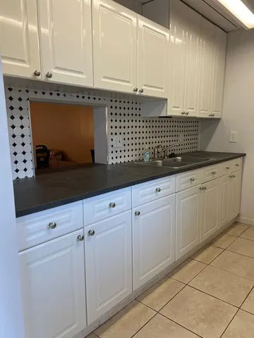 a kitchen with granite countertop white cabinets and sink