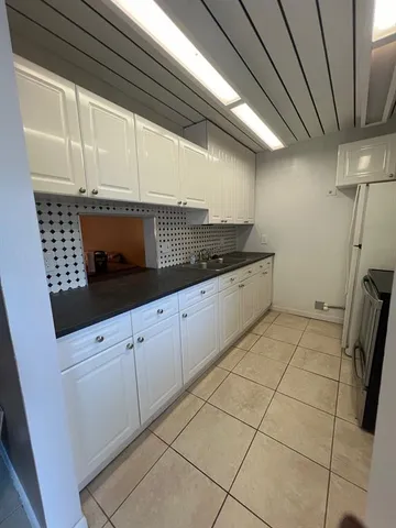a kitchen with granite countertop white cabinets and white appliances