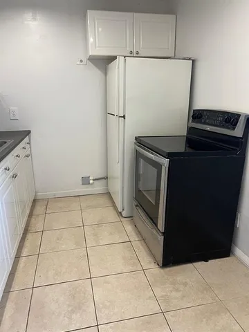 a kitchen with a stove top oven and cabinets