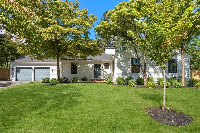 a view of a house with a big yard and large trees