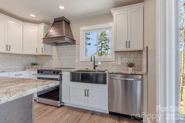 a kitchen with stainless steel appliances granite countertop a sink and cabinets