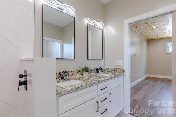 a bathroom with a granite countertop double vanity sink mirror and