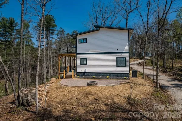 a view of a house with backyard and trees