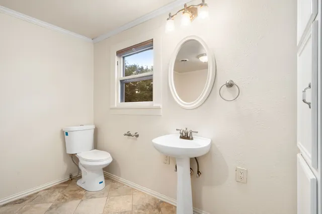a bathroom with a sink toilet and a mirror