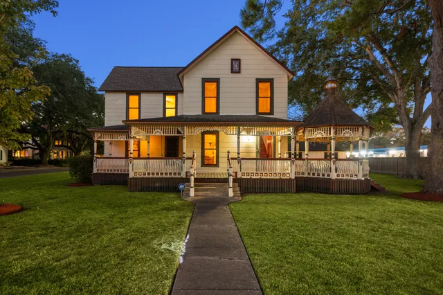 a front view of a house with a yard and trees