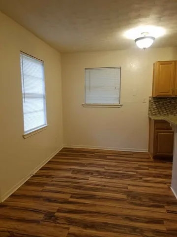 a view of a room with wooden floor and a fireplace