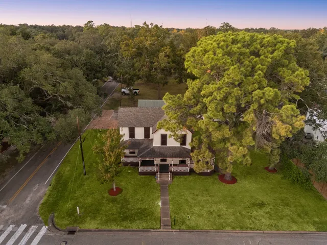 an aerial view of a house with a yard and lake view