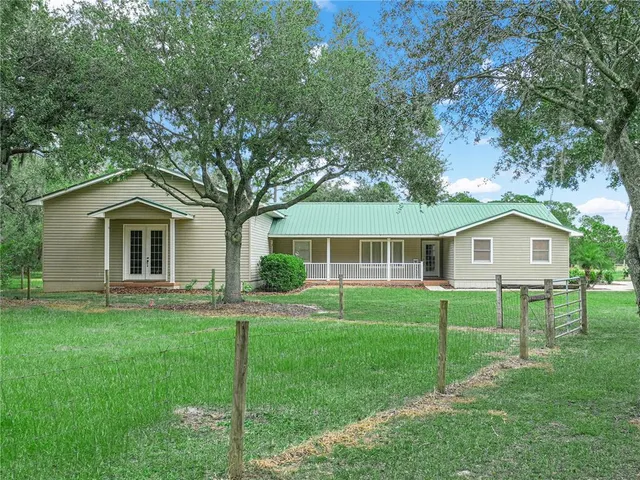 a front view of a house with a yard and trees
