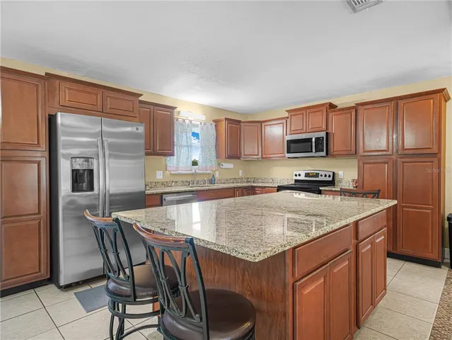 a kitchen with kitchen island a sink stove and refrigerator