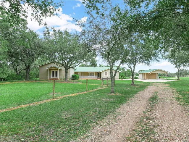 a front view of a house with a yard and trees