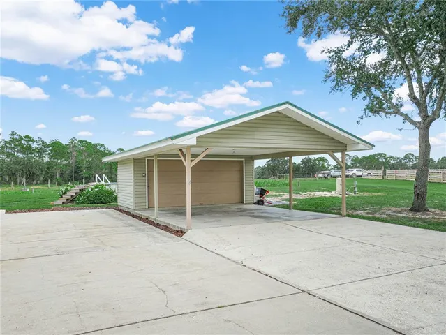 a view of a house with backyard and trees around