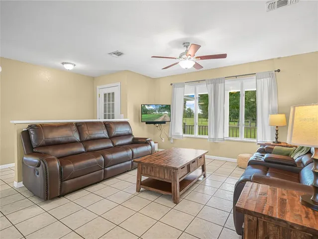 a living room with furniture and large windows