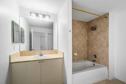 a bathroom with a tub a sink and mirror