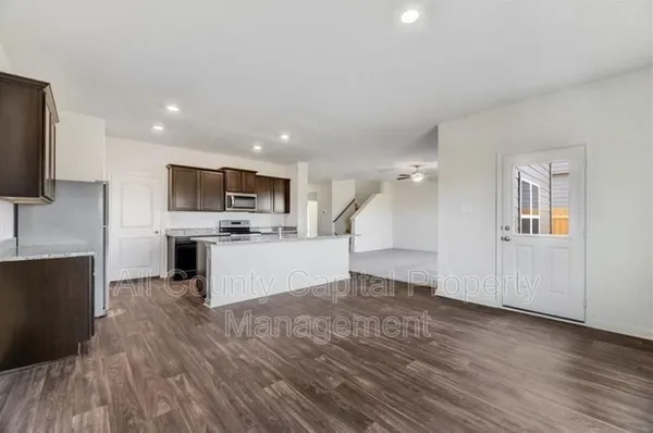 a view of kitchen with microwave refrigerator and cabinets