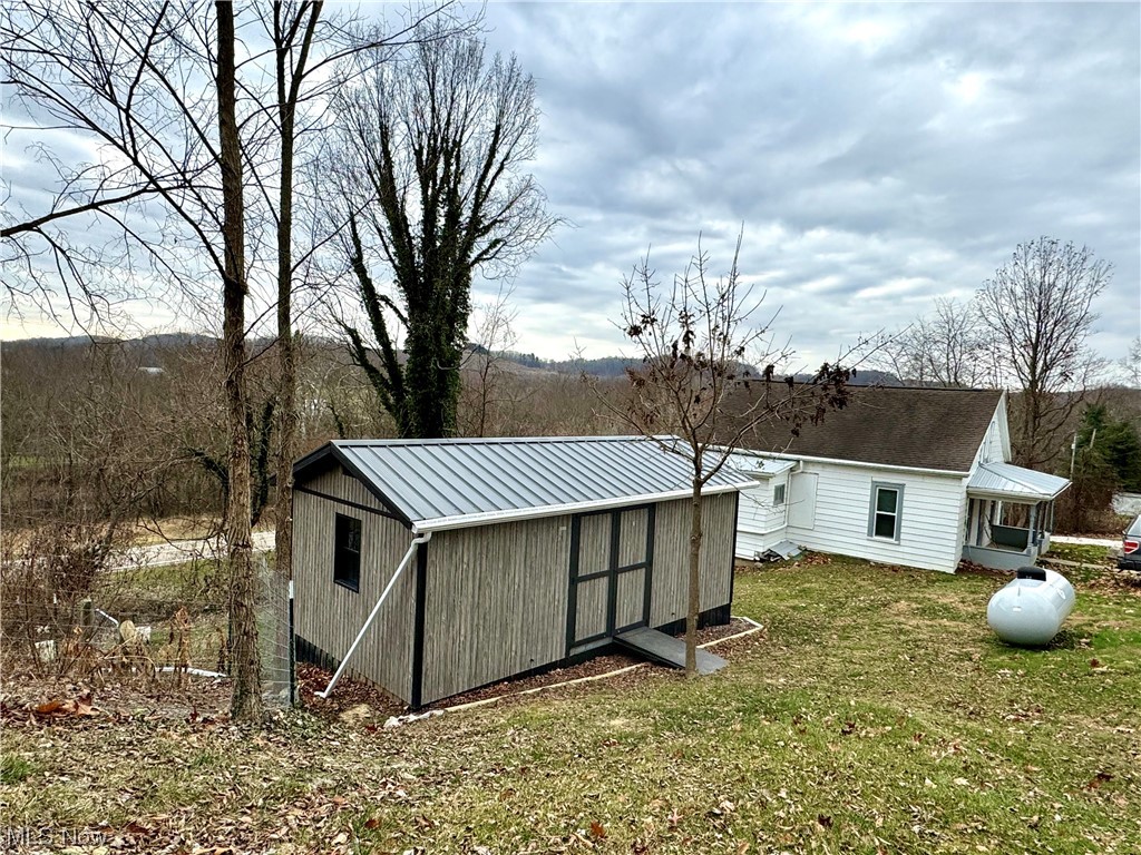 View of outdoor structure featuring a yard