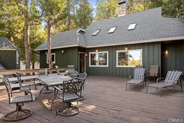 a view of a patio with table and chairs with wooden floor and fence