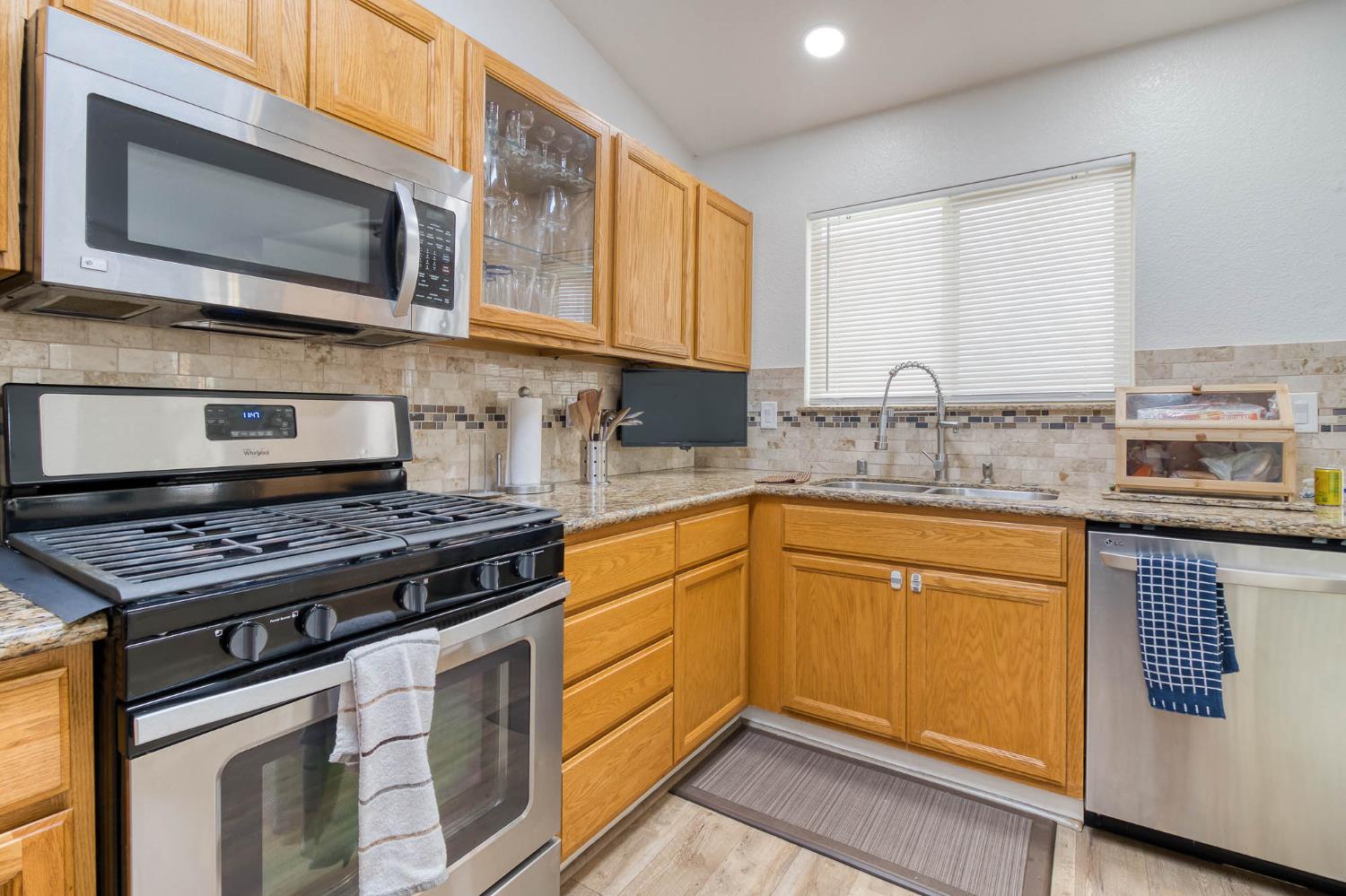 2913 Soquel Avenue Atwater, CA 95301 - Photo 14 of 29 a kitchen with stainless steel appliances granite countertop a stove microwave sink and cabinets
